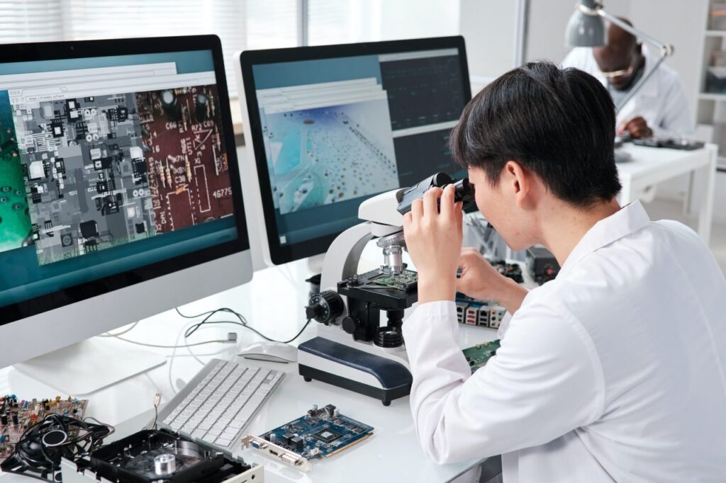 Young Asian female researcher looking in microscope